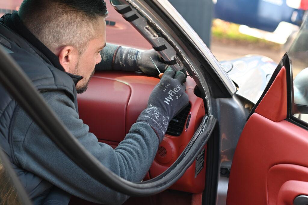 Intervention sur un pare-brise de Porsche 911 intérieur en cuir rouge
