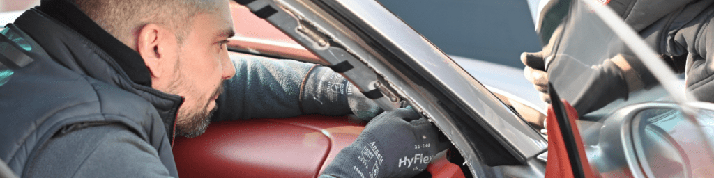 Technicien RS Glass en intervention sur un pare-brise à l'intérieur du véhicule